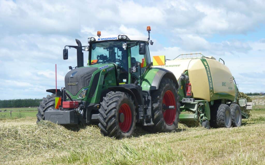 A large balage tractor unit working in a paddock on a sunny day