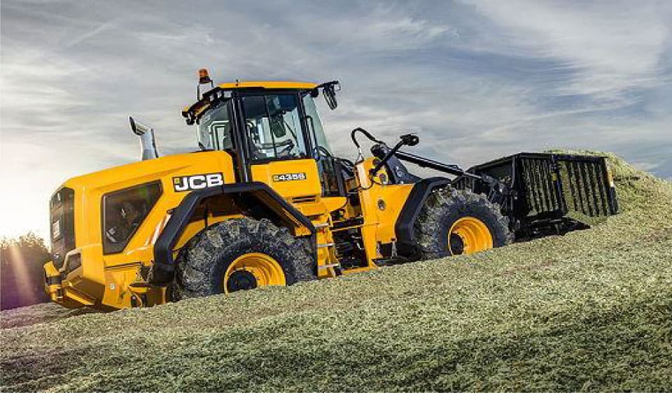 Large yellow balage silage machine working in a paddock