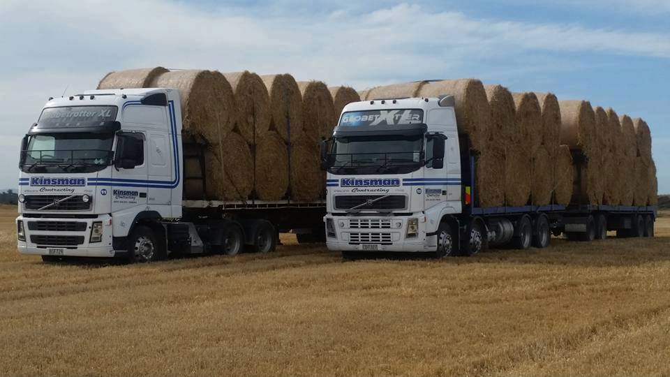 Kinsman trucks loaded with straw bales for cartage